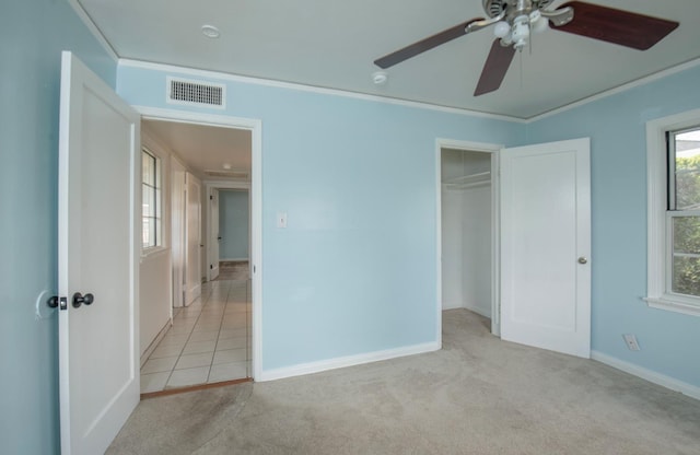 unfurnished bedroom featuring visible vents, light carpet, and ornamental molding