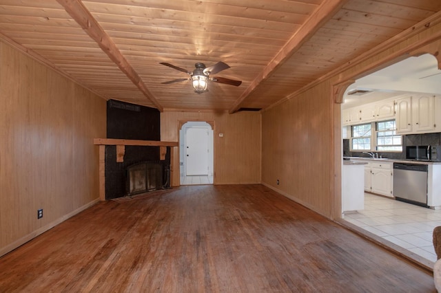 unfurnished living room with a fireplace, arched walkways, ceiling fan, wood ceiling, and light wood-type flooring