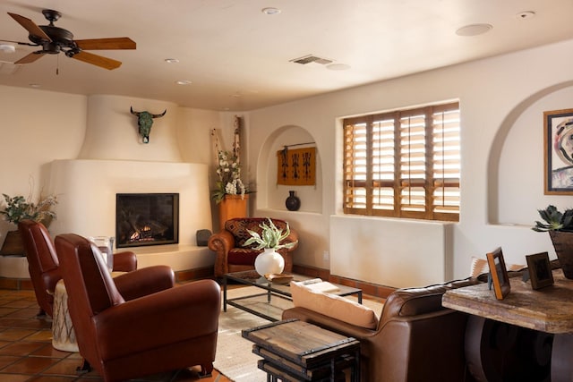 tiled living area featuring visible vents, a fireplace, and a ceiling fan