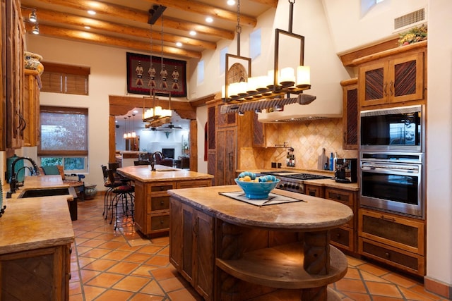 kitchen with a kitchen island with sink, visible vents, open shelves, stainless steel appliances, and a sink