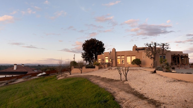 adobe home with stucco siding and fence