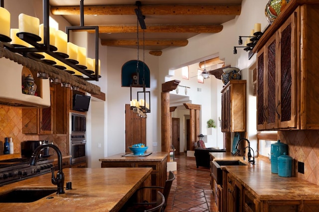 kitchen with beamed ceiling, backsplash, oven, and a sink