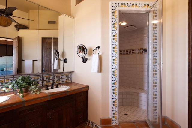 bathroom with visible vents, a shower stall, vanity, and ceiling fan