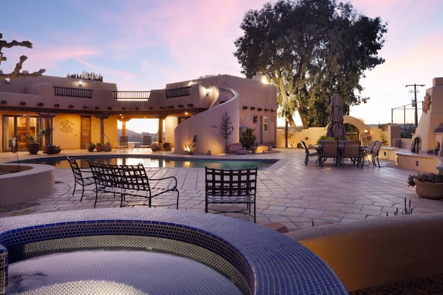 view of patio featuring an outdoor pool and a jacuzzi