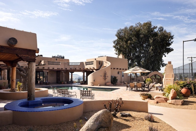 pool with an in ground hot tub and a patio area