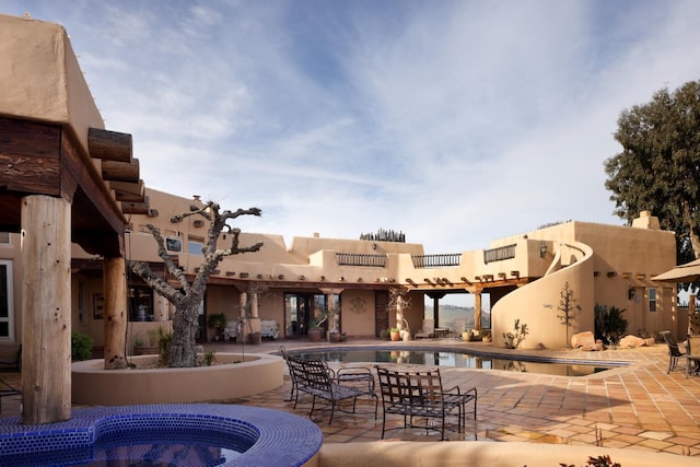 community pool featuring a patio area and a community hot tub