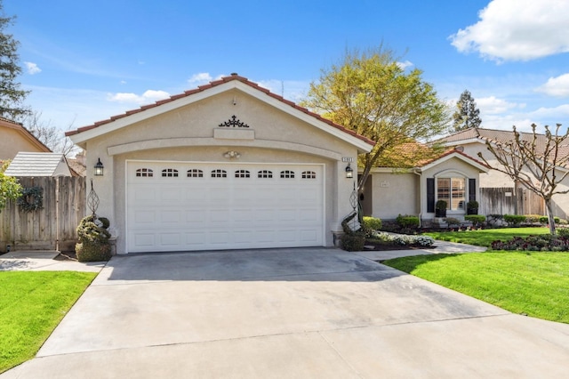 view of front facade with fence, concrete driveway, a front yard, stucco siding, and a garage