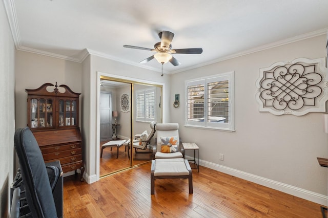 living area featuring baseboards, light wood-style floors, ceiling fan, and ornamental molding