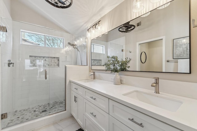 bathroom featuring a sink, a stall shower, and vaulted ceiling