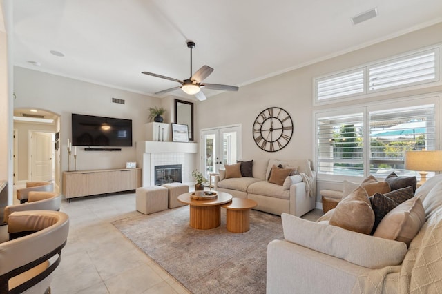 living room featuring light tile patterned flooring, a healthy amount of sunlight, crown molding, and ceiling fan