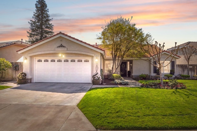 view of front of home featuring stucco siding, driveway, a front lawn, and fence