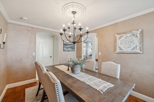 dining area featuring baseboards, arched walkways, an inviting chandelier, and wood finished floors