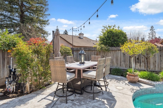 view of patio / terrace featuring outdoor dining area, a fenced in pool, and a fenced backyard