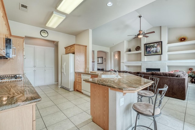 kitchen featuring visible vents, built in features, a sink, stainless steel appliances, and a peninsula