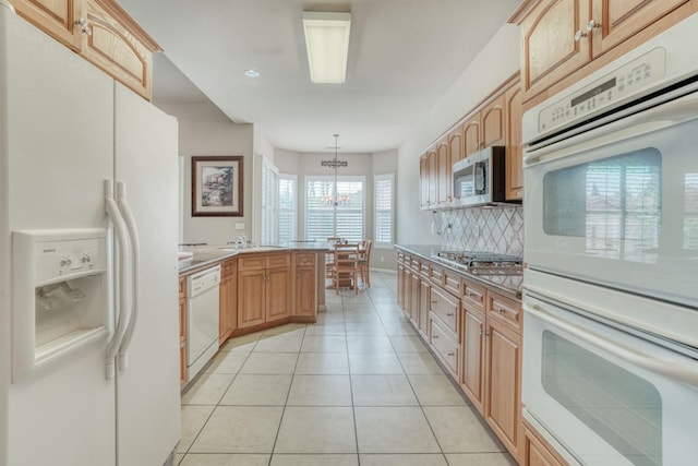 kitchen with light tile patterned flooring, decorative backsplash, light countertops, appliances with stainless steel finishes, and a chandelier