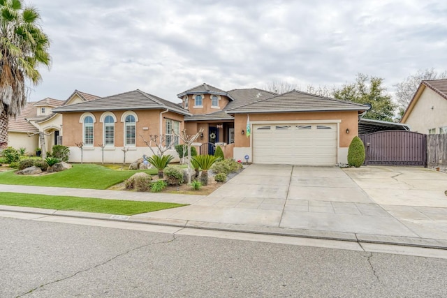 view of front of home with stucco siding, concrete driveway, an attached garage, and a gate