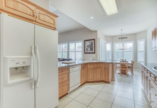 kitchen featuring decorative light fixtures, white appliances, an inviting chandelier, light tile patterned flooring, and light countertops