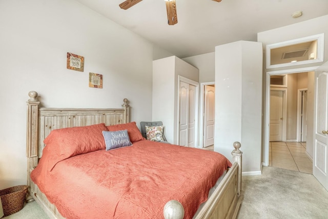 carpeted bedroom featuring a closet, visible vents, tile patterned flooring, and a ceiling fan