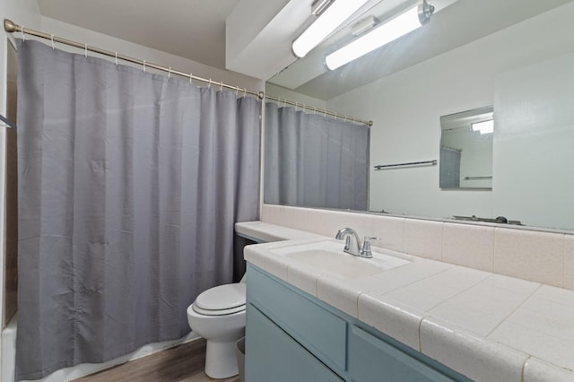 full bathroom featuring toilet, vanity, and wood finished floors