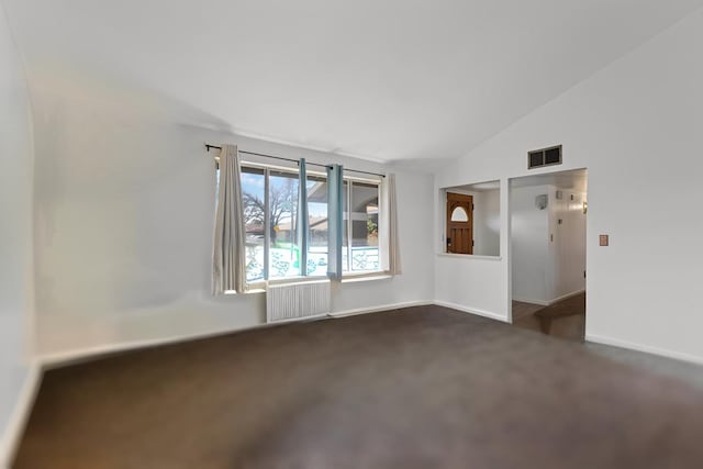 unfurnished room with visible vents, radiator, baseboards, dark carpet, and vaulted ceiling