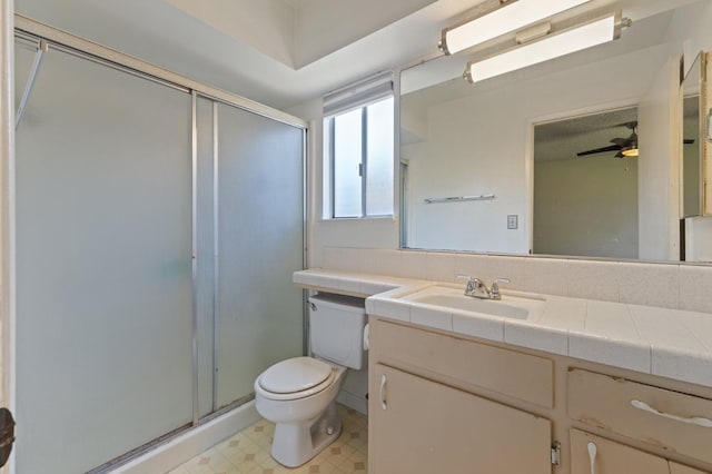 bathroom featuring tile patterned floors, toilet, a stall shower, and vanity