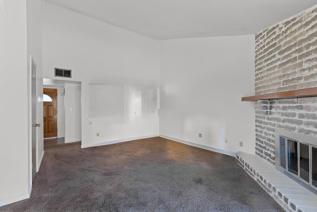 unfurnished living room featuring visible vents, baseboards, a towering ceiling, and a fireplace