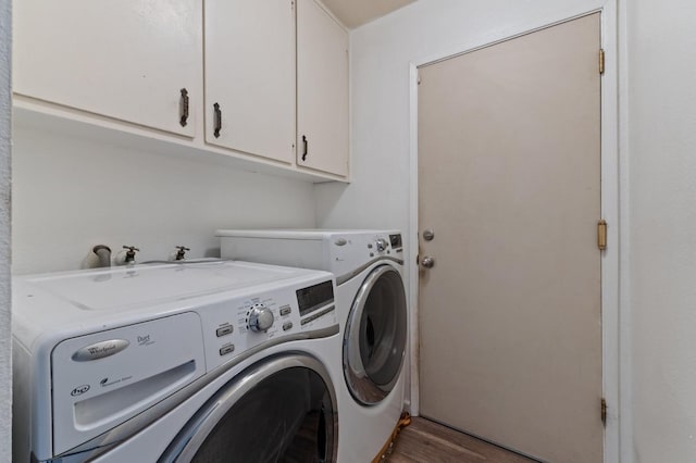 laundry room featuring wood finished floors, cabinet space, and washer and clothes dryer