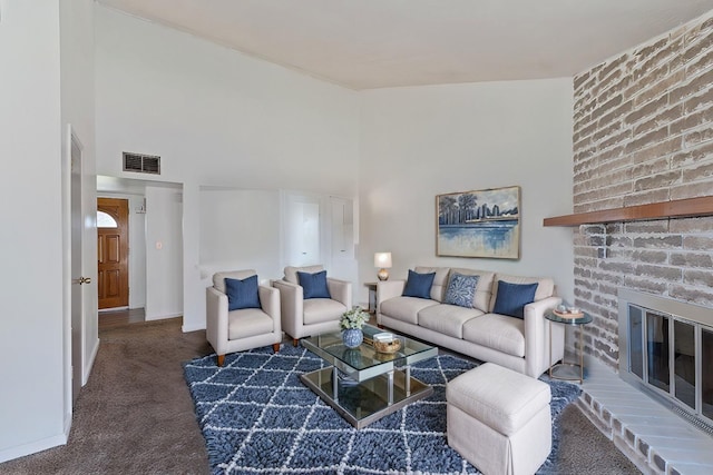 carpeted living room with a high ceiling, a fireplace, visible vents, and baseboards