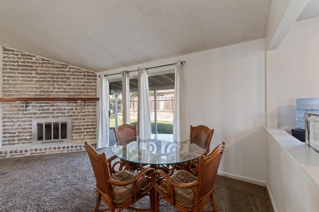 dining room with baseboards, lofted ceiling, carpet floors, a fireplace, and a textured ceiling