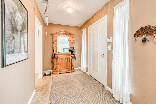 corridor featuring visible vents and baseboards