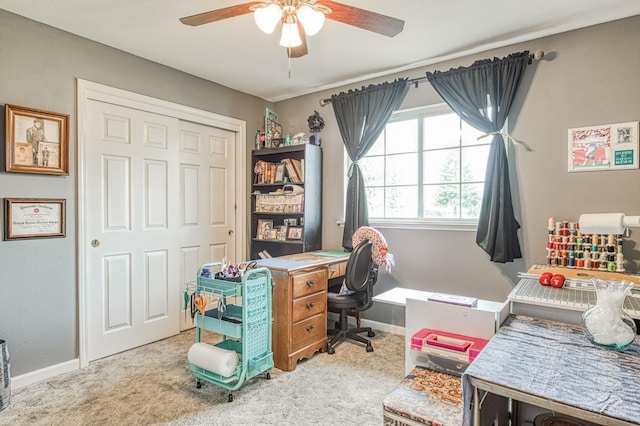 carpeted office with baseboards and a ceiling fan