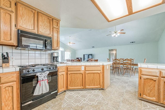 kitchen featuring black appliances, tile countertops, a peninsula, ceiling fan, and vaulted ceiling