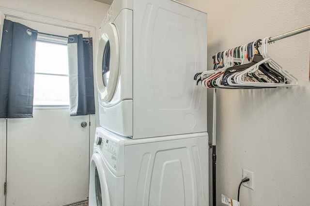 clothes washing area with laundry area and stacked washing maching and dryer