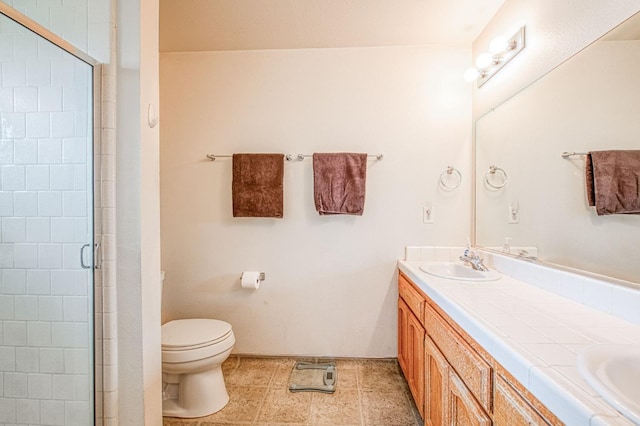 bathroom with double vanity, toilet, a stall shower, and a sink