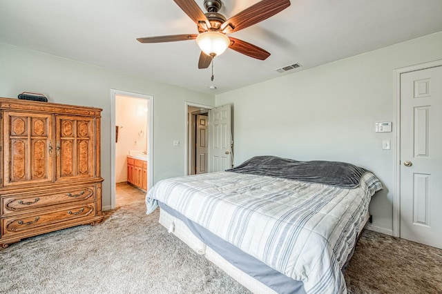 bedroom with a ceiling fan, ensuite bath, light colored carpet, and visible vents