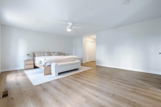 unfurnished bedroom featuring ceiling fan, wood finished floors, visible vents, and baseboards