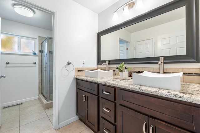 bathroom with visible vents, double vanity, a stall shower, a sink, and tile patterned flooring