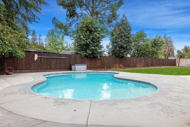 view of swimming pool with a yard, a fenced in pool, a patio, and a fenced backyard