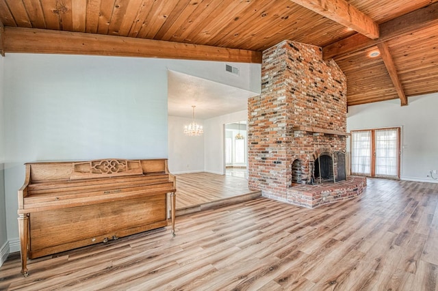 unfurnished living room with beamed ceiling, visible vents, wood finished floors, wooden ceiling, and baseboards