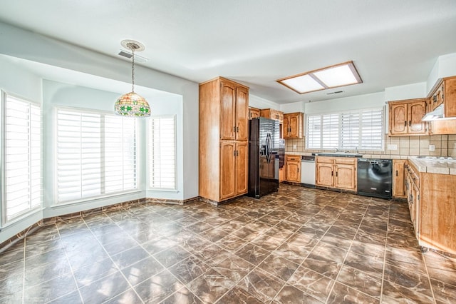 kitchen with black appliances, decorative light fixtures, a sink, tasteful backsplash, and brown cabinetry