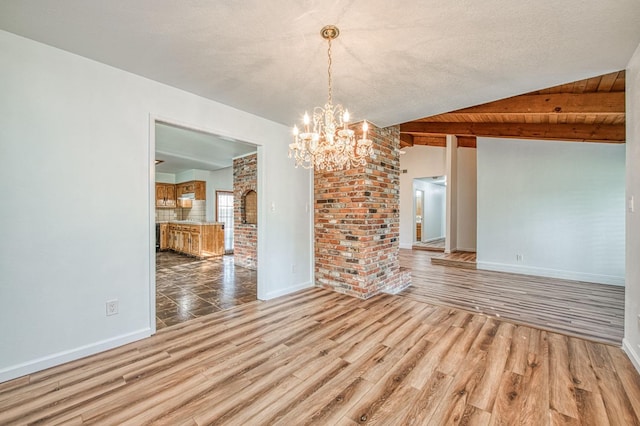 unfurnished dining area featuring a chandelier, baseboards, wood finished floors, and vaulted ceiling with beams