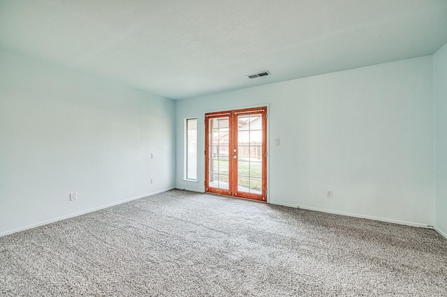 empty room with visible vents, baseboards, and carpet