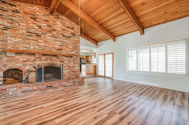 unfurnished living room featuring wood ceiling, beam ceiling, a fireplace, wood finished floors, and high vaulted ceiling