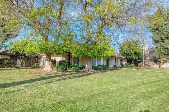 view of front facade featuring a front yard and fence