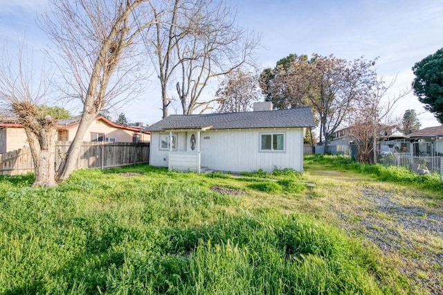 back of property featuring a chimney and fence