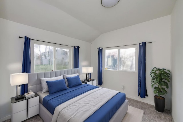 carpeted bedroom with multiple windows, baseboards, and lofted ceiling