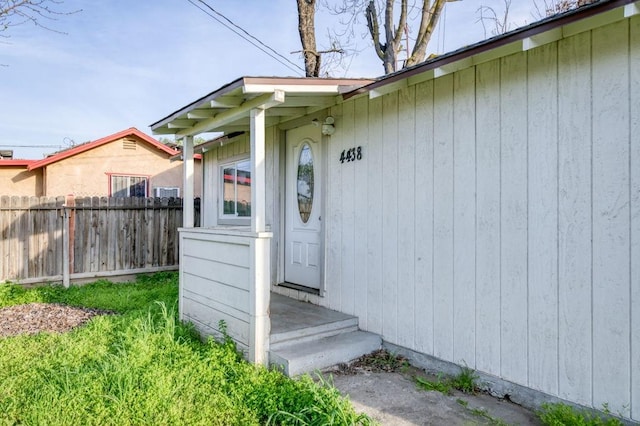 doorway to property featuring fence