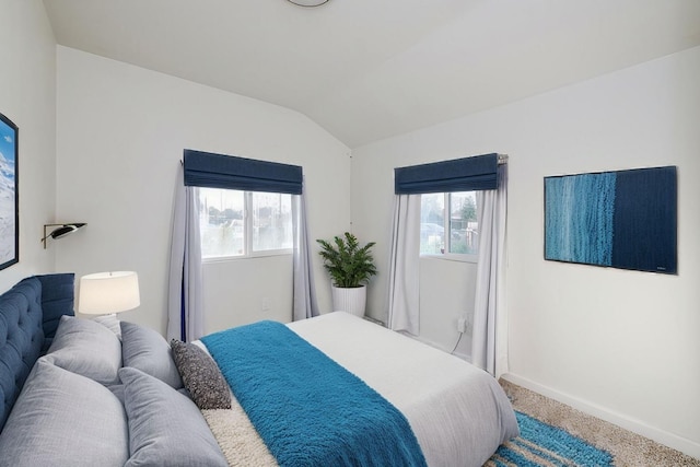 bedroom with multiple windows, baseboards, carpet, and vaulted ceiling