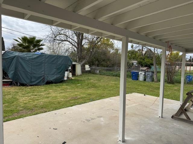 view of patio / terrace featuring an outbuilding, a shed, and fence