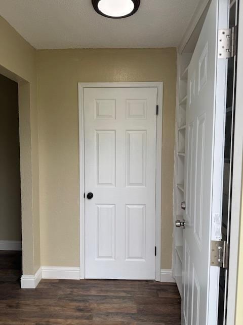 hall with dark wood finished floors and baseboards